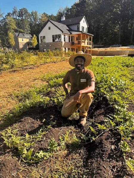 Vincent McKoy kneeling in dirt at Pendergrast Farm